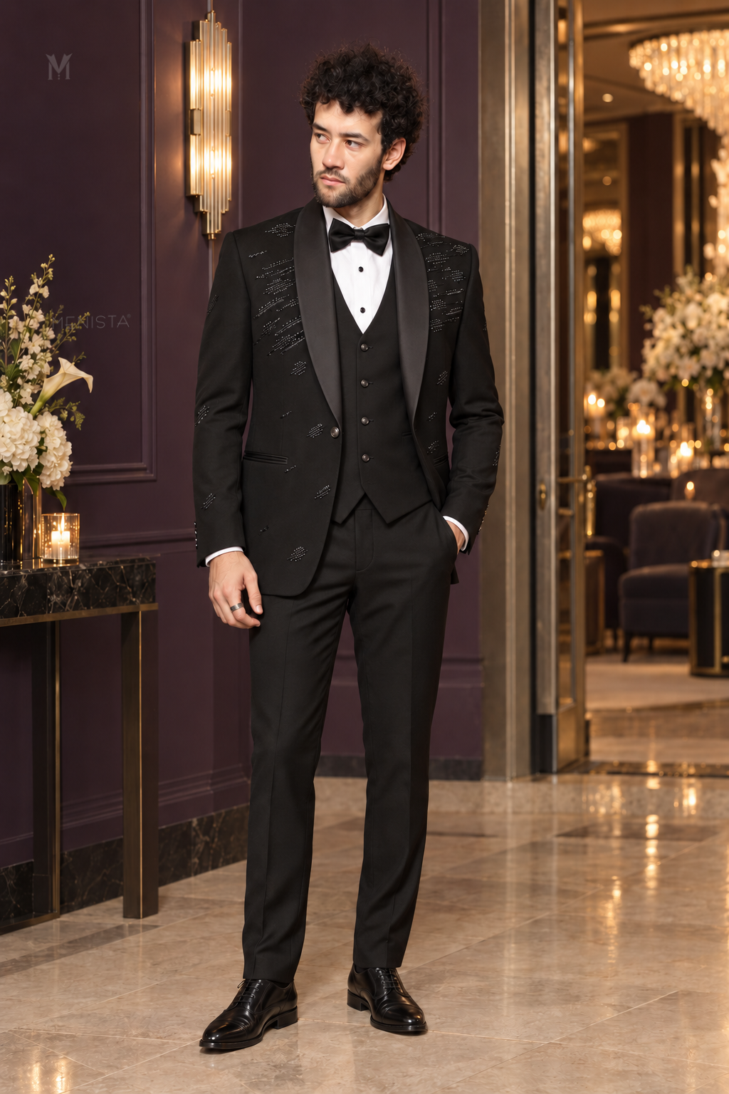 Michael wearing Noctis black abstract beaded three-piece tuxedo with satin shawl lapels in a plum wedding venue.