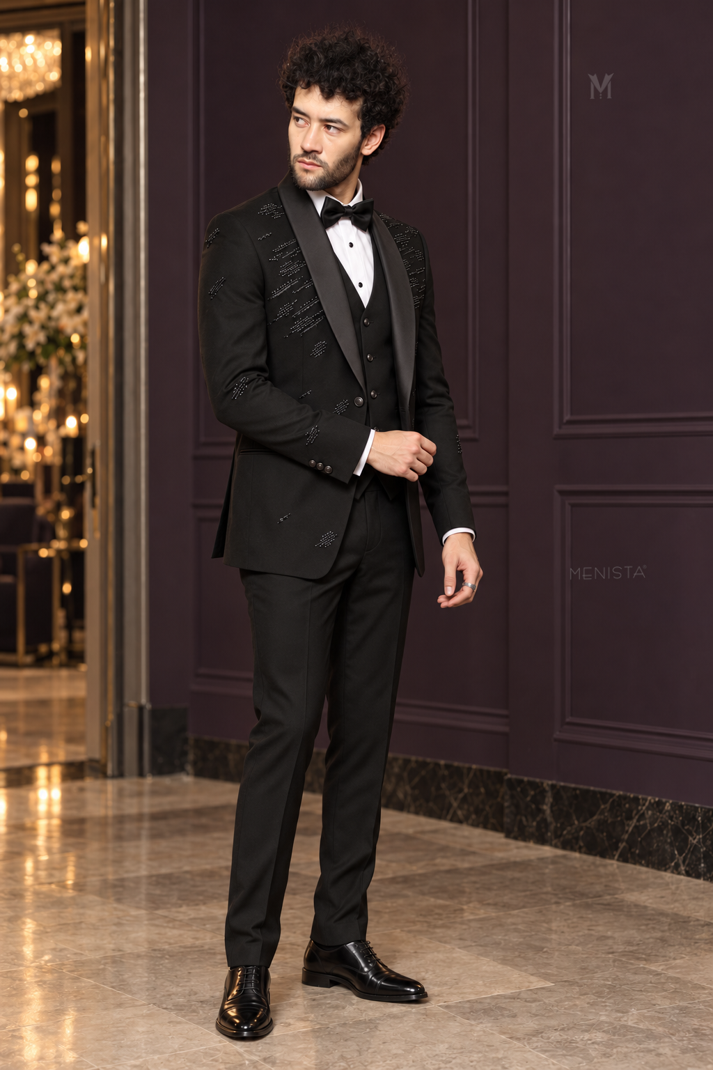 Three-quarter view of Noctis black tuxedo showing beaded streaks, one jacket button and slim silhouette.