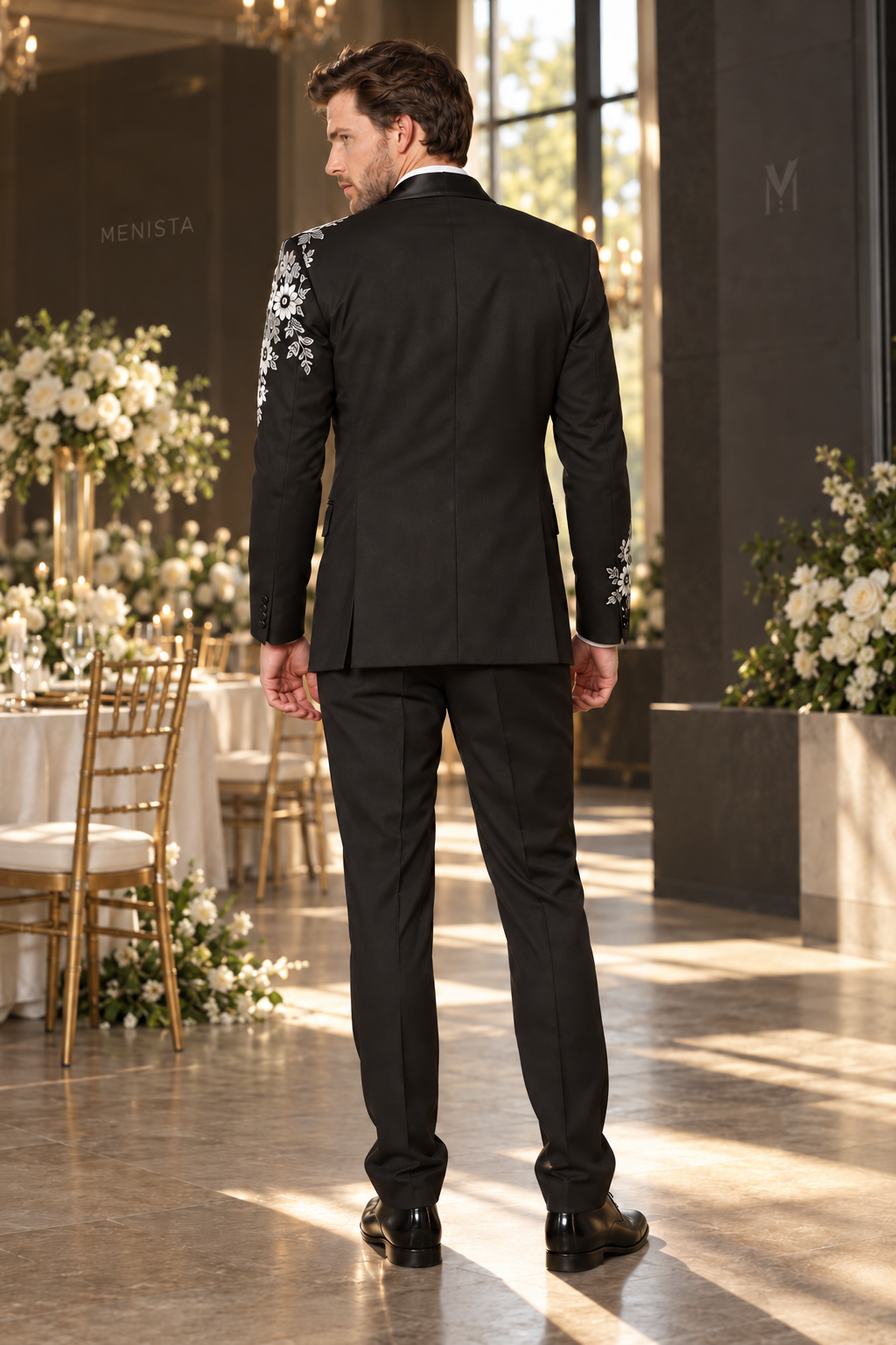 Full back view of Alaric black tuxedo with daisy embroidery wrapping the sleeves and plain matching trousers.