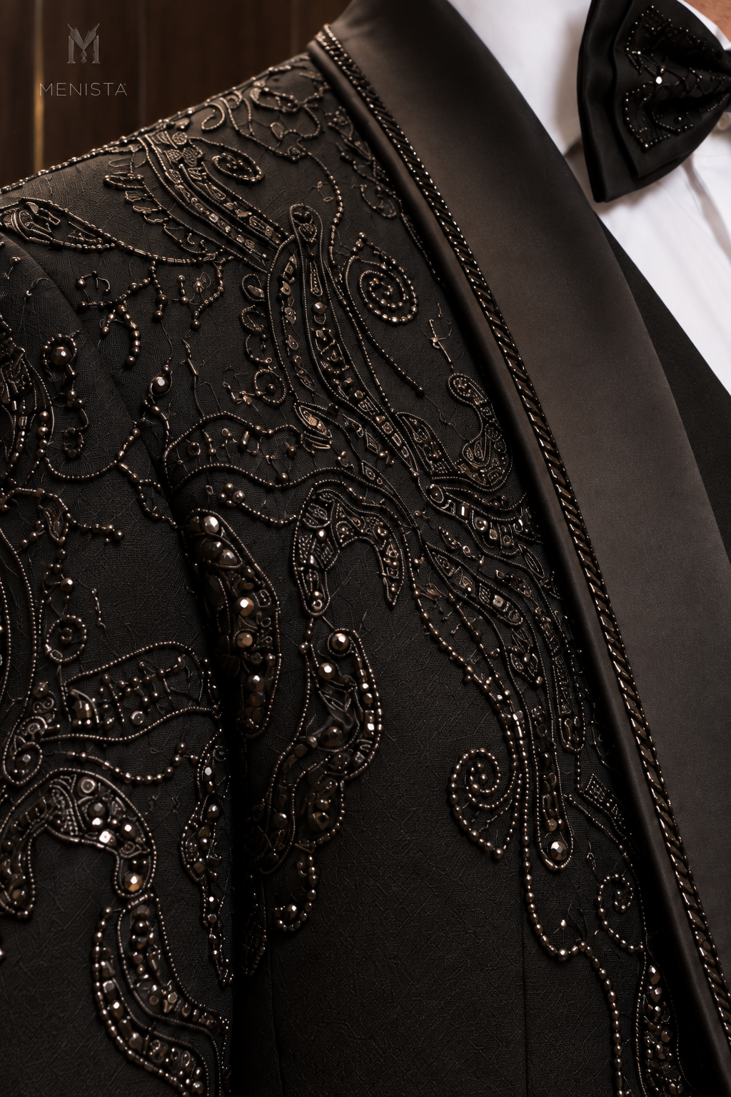 Close-up of Alder gunmetal paisley bead embroidery and black satin shawl lapel
