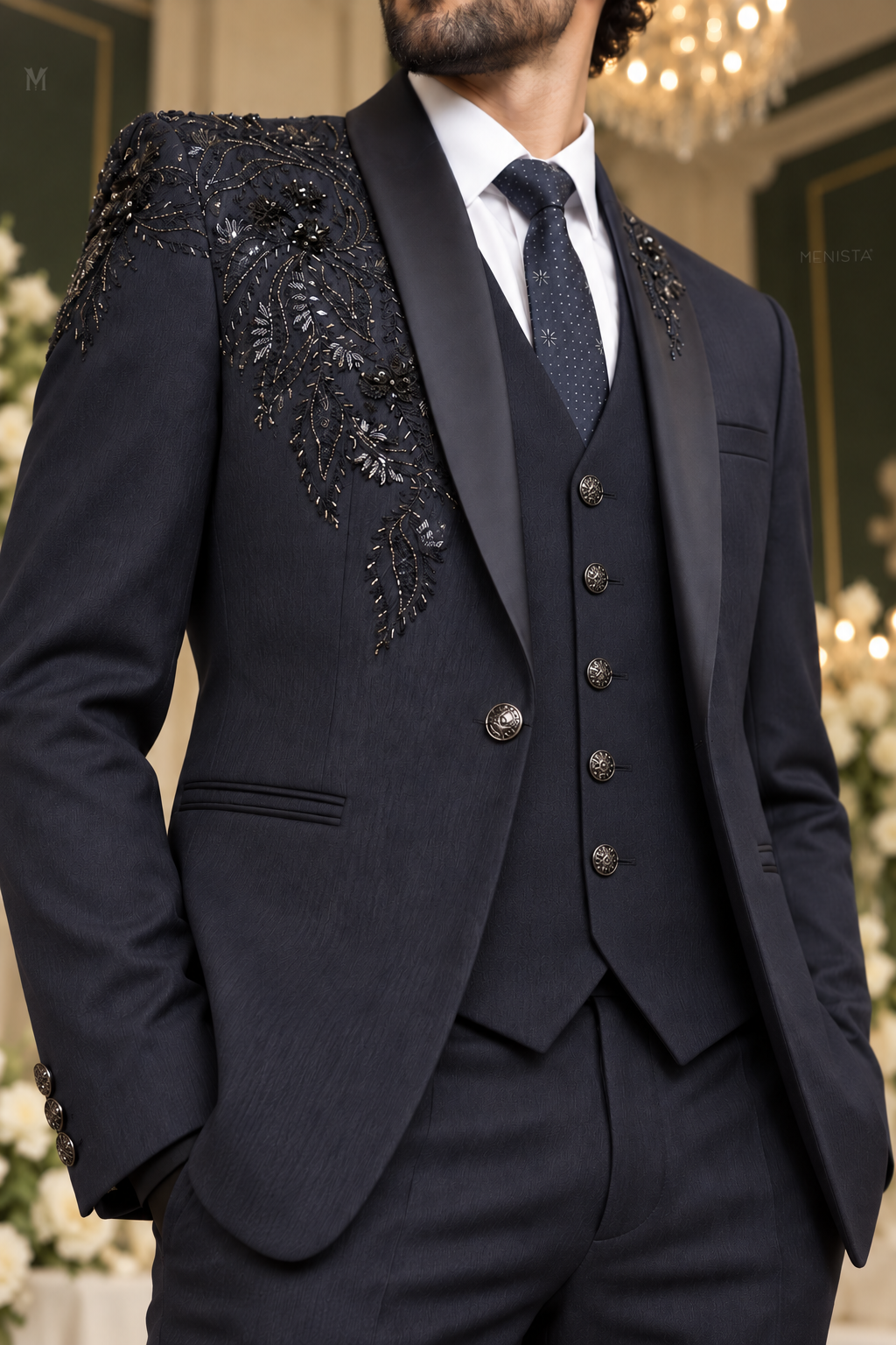 Close-up of Cassian navy floral and paisley bead embroidery, satin shawl lapels, single jacket button and five-button waistcoat.
