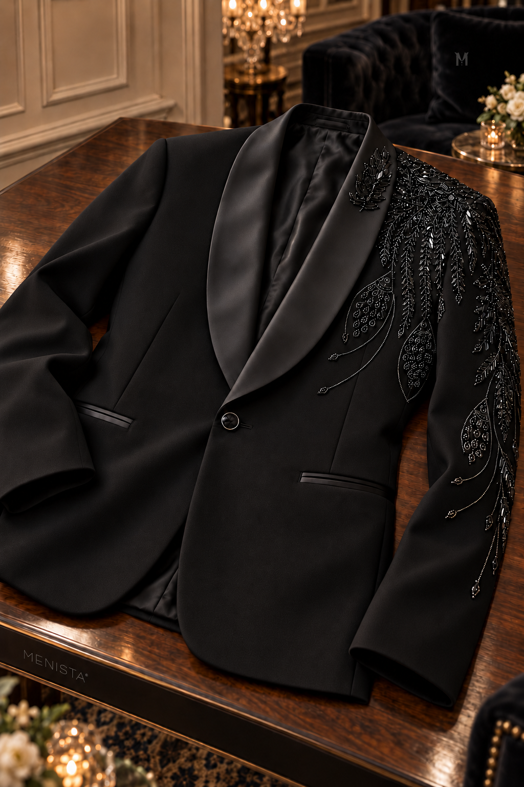 Aurel black floral embroidered tuxedo jacket on a wooden table, showing satin shawl lapels, beadwork and jetted pockets.
